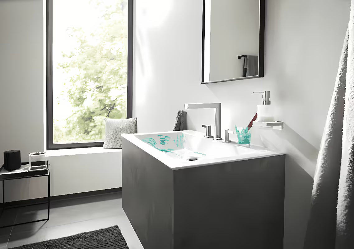 Chromovaný nástěnný dávkovač tekutého mýdla hansgrohe AddStoris se skleněnou nádobou a kovovým držákem.