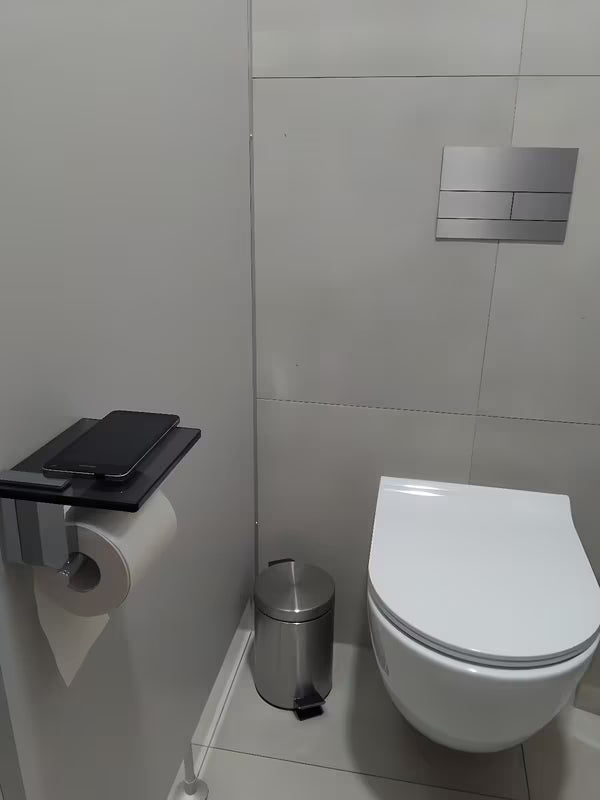 Černý držák toaletního papíru SAT Cube Way s odkládací poličkou z kaleného bezpečnostního skla.
