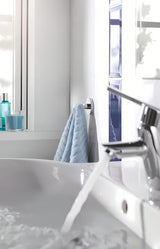 Chromový háček na župan Grohe Essentials se skrytým upevněním na kruhové nástěnné destičce.