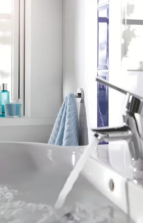 Chromový háček na župan Grohe Essentials se skrytým upevněním na kruhové nástěnné destičce.