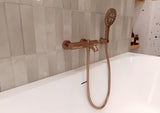 Nástěnný držák sprchy Grohe Rainshower s kulatou rozetkou v povrchové úpravě Brushed Warm Sunset.