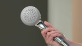Ruční sprcha Hansgrohe Crometta 85 Mono v chromu s kulatou hlavicí a světle šedým diskem trysek.