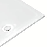 Bílý designový sifon k sprchové vaničce s krytkou, který nevyčnívá nad povrch vaničky.