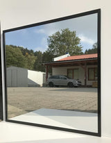 Koupelnové zrcadlo Naturel s černým hliníkovým rámem o rozměru 80 x 80 cm.