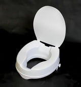 Bílé zvýšené WC sedátko Ridder z polypropylenu pro pohodlnější sedání a vstávání